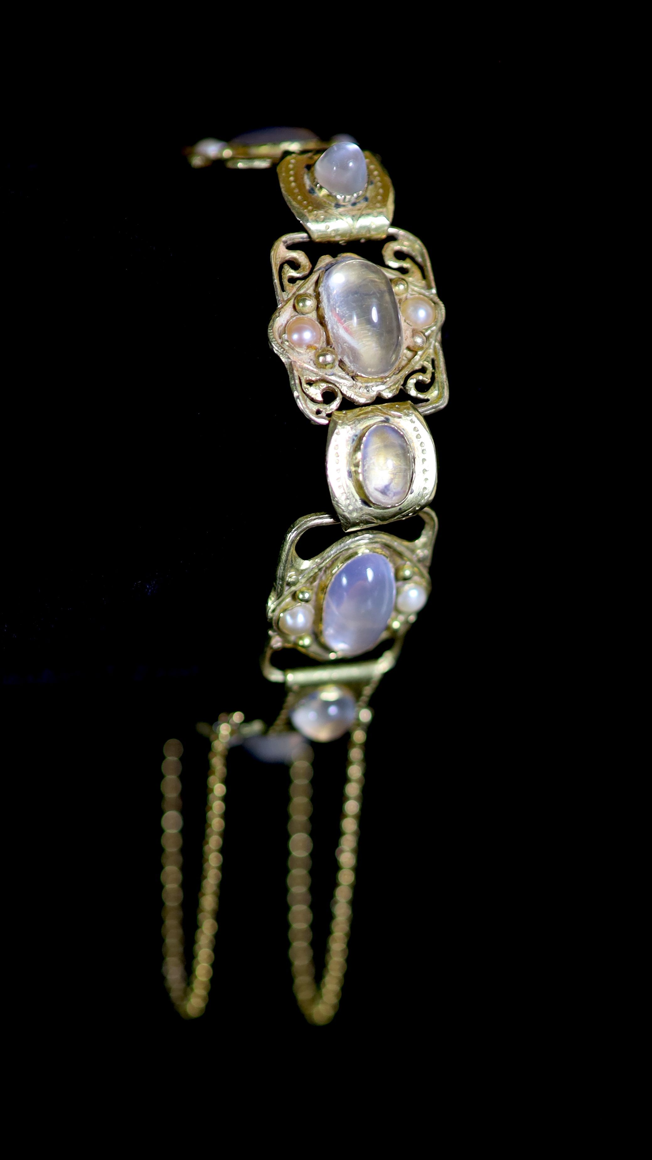 An early 20th century Arts & Crafts gold, cabochon moonstone and split pearl set bracelet